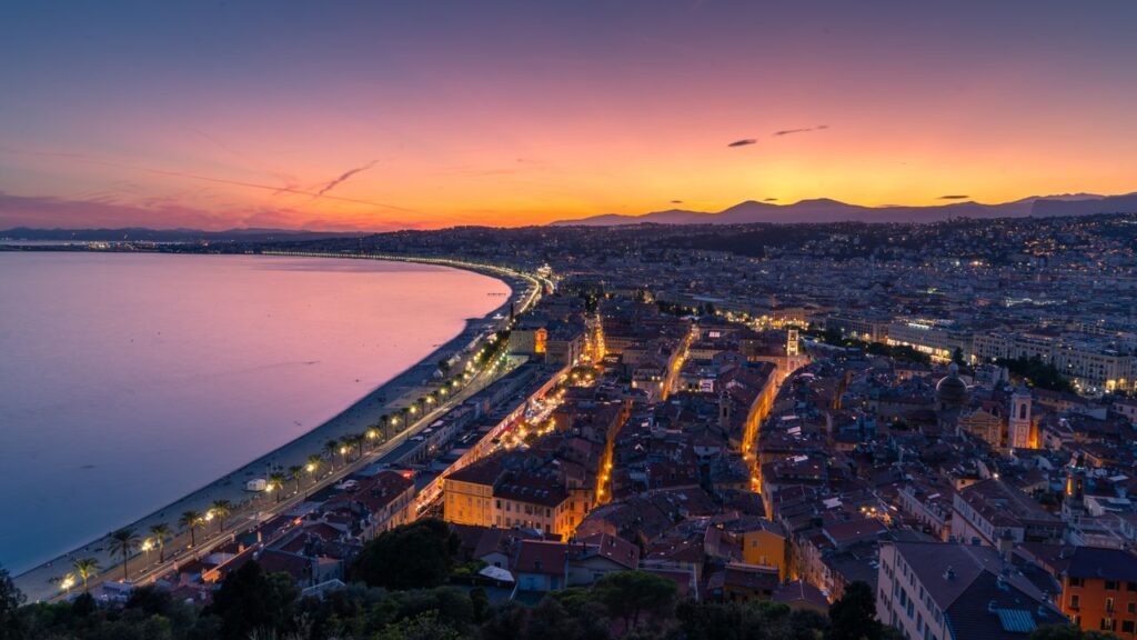 Breathtaking sunset view over Nice, France, featuring the Mediterranean coastline and vibrant city lights.
